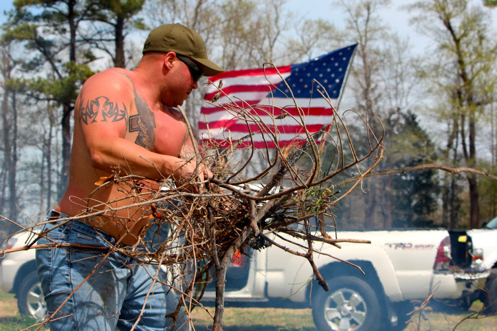 Joshua Xenakis, a captain with the city fire department, clears vines on the farm. An army of volunteers have helped support Bukowski’s vision for LZ-Grace. [John-Henry Doucette/The Princess Anne Independent News]