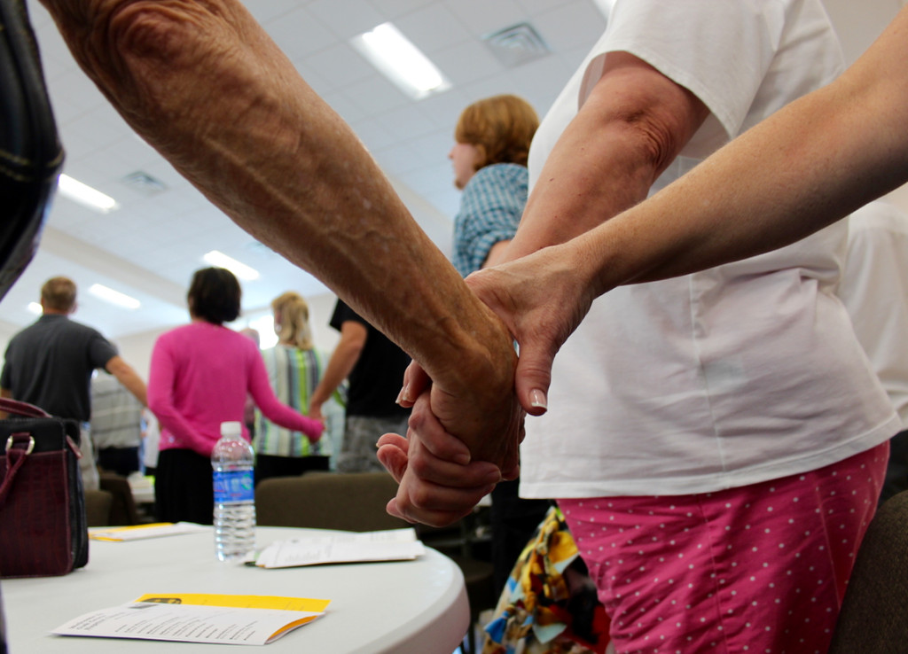 Members of Oak Grove Baptist Chruch, friends and guests join hands amid prayer toward the end of a special service in the church’s new multipurpose building in July. [John-Henry Doucette/The Princess Anne Independent News] 