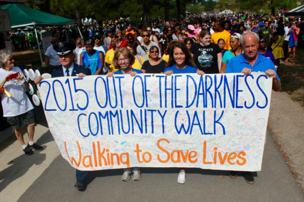 Air Force Brig. Gen. Sean Murphy, Sandy Bodenhamer of Kings Grant, Christopher Newport University student Courtney Morgan and Mayor Will Sessoms carry the banner at the start of this year’s Out of the Darkness Community Walk at Mount Trashmore. [John-Henry Doucette/The Princess Anne Independent News]