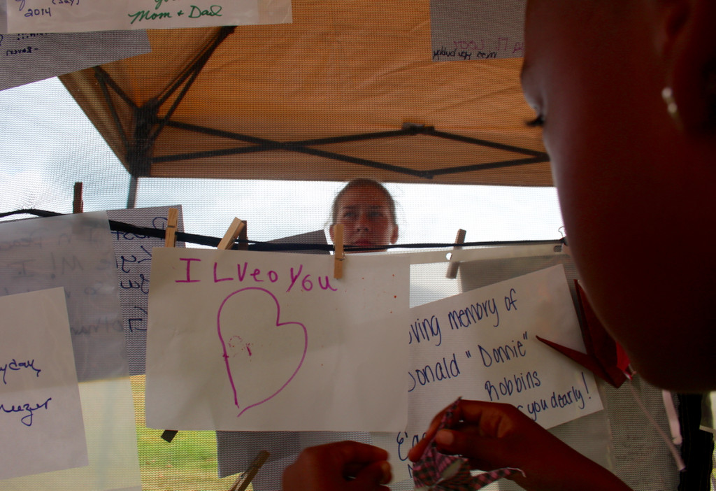 Nia Jones, 6, of Yorktown places a paper crane on the memory wall during the Out of the Darkness Community Walk event in September. [John-Henry Doucette/The Princess Anne Independent News] 