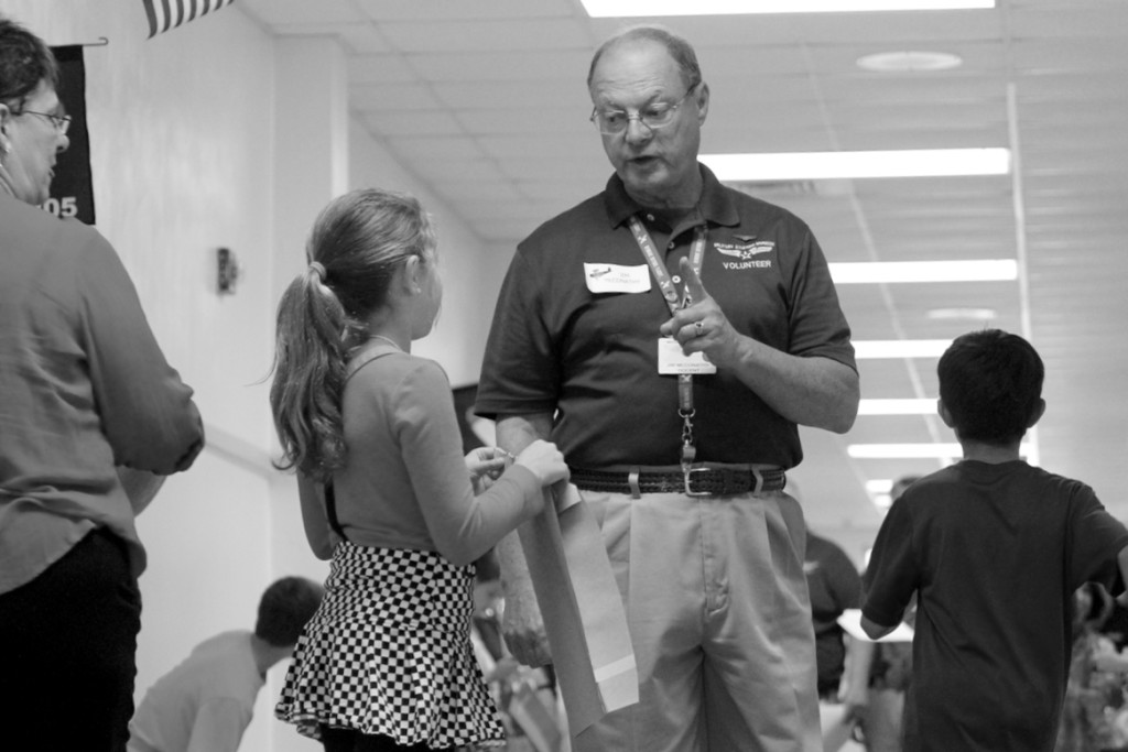 Meadow Cortazzo, 10, of Blackwater, consults with Military Aviation Museum docent Jim McConathy.  [John-Henry Doucette/The Princess Anne Independent News]