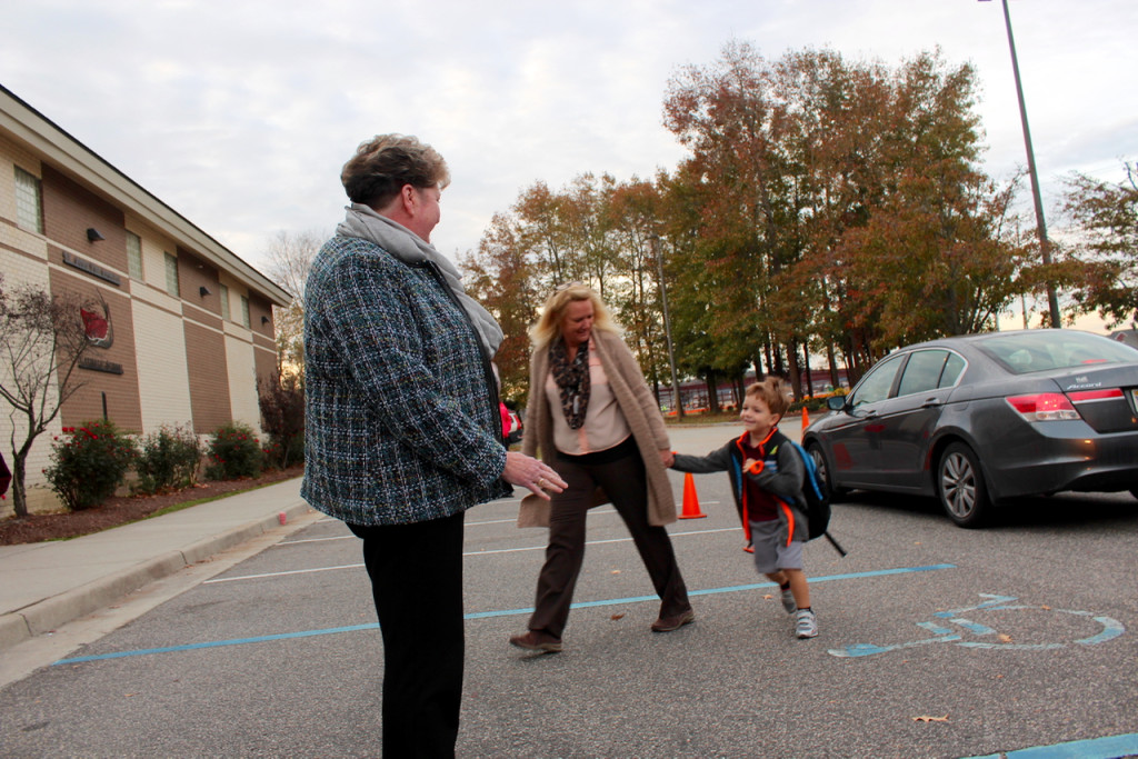 At right, Miriam Cotton, principal of St. John the Apostle Catholic School, greets students as they arrive early on Tuesday, Nov. 17. [John-Henry Doucette/The Princess Anne Independent News]
