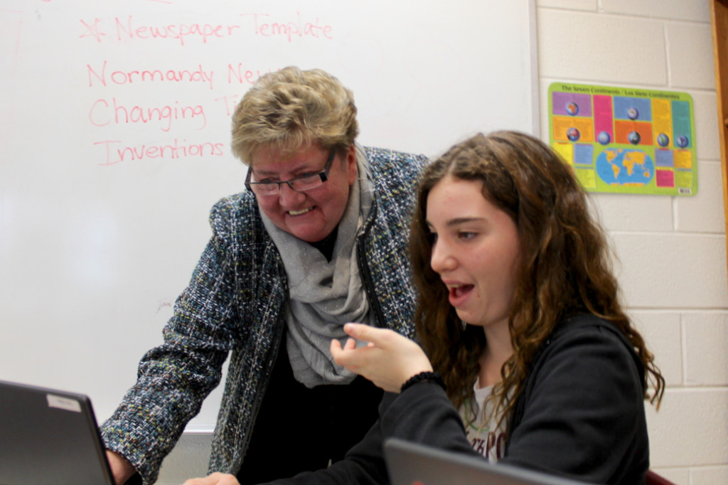 Cotton, in her first year as principal, has placed an emphasis on technology in the classroom. Below, Cotton smiles while Cate Gleim, 12, shows some of her work on a computer. [John-Henry Doucette/The Princess Anne Independent News]