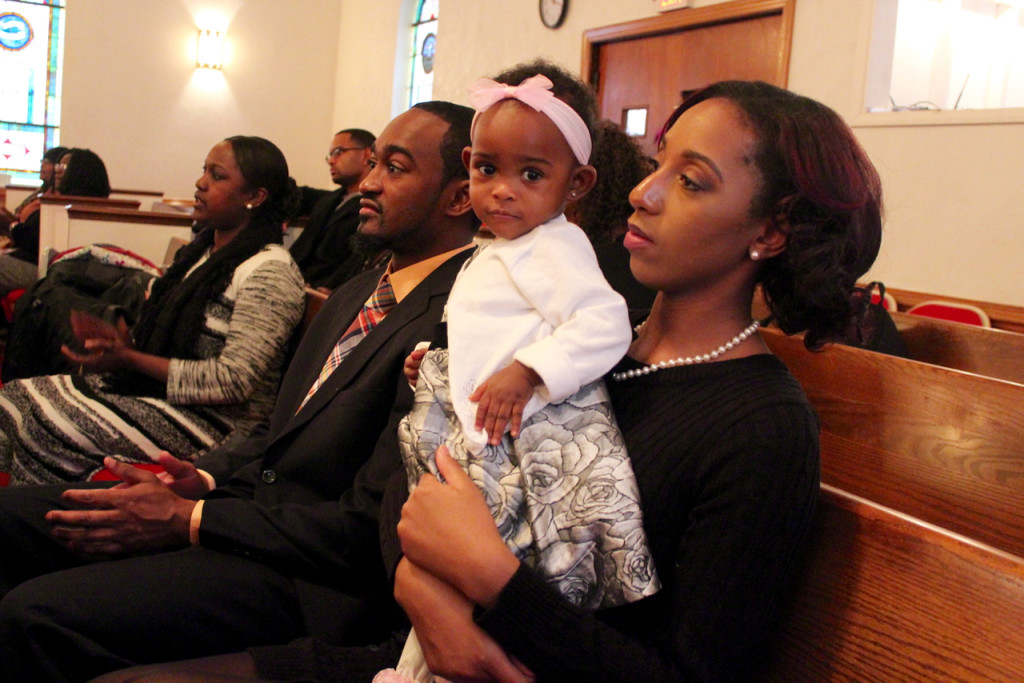 Camrynn Ricks, who is a year old, sits with her parents, Cecil Ricks and Renae Simmons. Earlier in the service, Wilson said: “God has blessed us with youth, and we should push them as far as we can. They are not the church of tomorrow. They are the church of today.” [John-Henry Doucette/The Princess Anne Independent News]