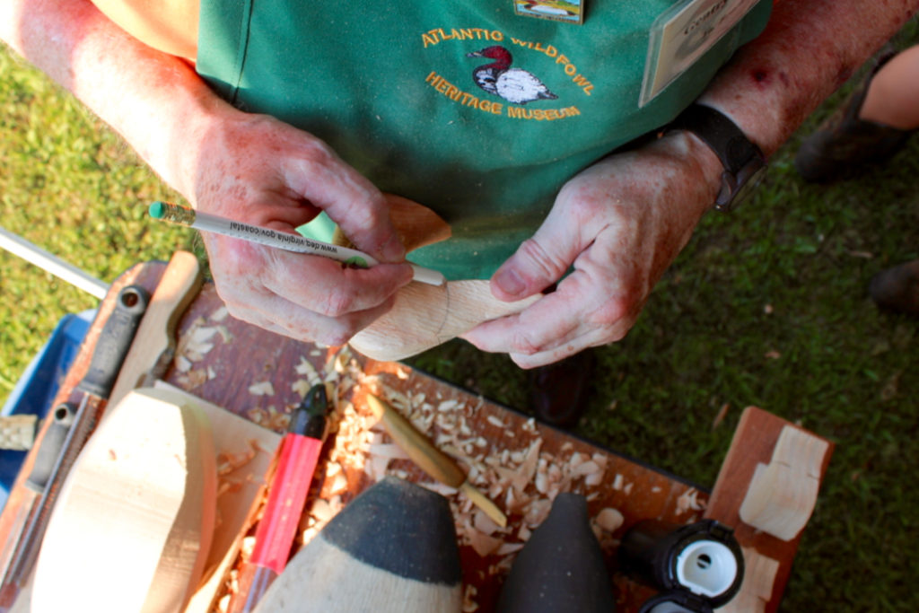 Gentry Childress, 72, of the North End in Virginia Beach, demonstrates decoy carving as a representative of the Atlantic Wildfowl Heritage Museum during the banquet. [John-Henry Doucette/The Princess Anne Independent News]