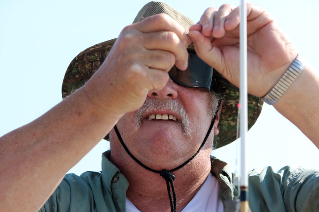 Bob Stocker of Great Bridge baits a hook for one of the young people. [John-Henry Doucette/The Princess Anne Independent News]