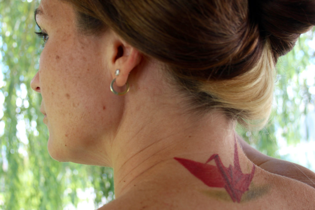 Rita Ann Bell is seen at her home on Friday, Aug. 12. Bell got this tattoo of a red origami crane in remembrance of her mother, Rita Hughes, who lost her battle with depression in 2004. The crane represents hope for peace, and its color represents the loss of a parent. [John-Henry Doucette/The Princess Anne Independent News]
