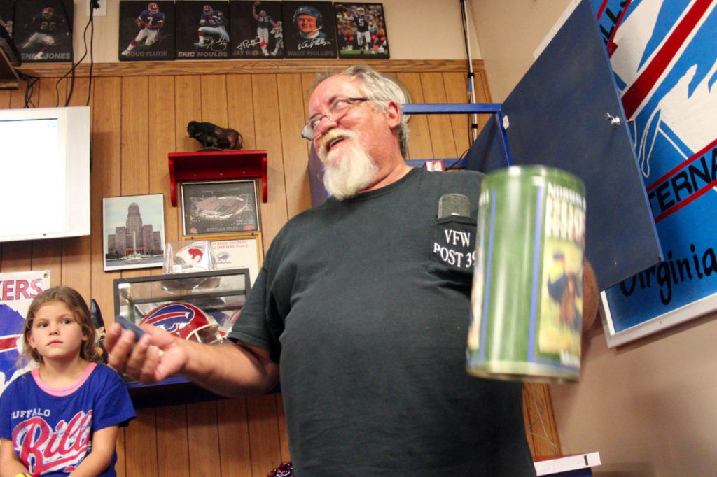 Howard Rochelle, originally from Buffalo, N.Y., handles the raffle after the game for members of the Bills Backers of Virginia Beach while Kailyn Carey, 7, looks on. [John-Henry Doucette/The Princess Anne Independent News]