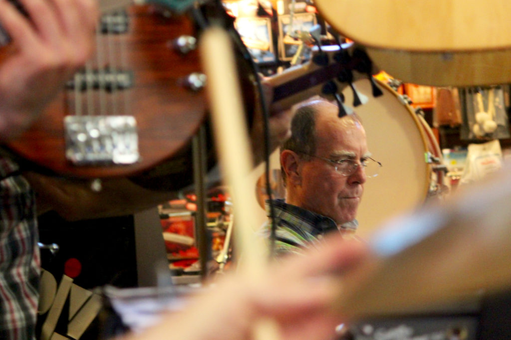 Scarborough, proprietor of Russell’s Music World, is seen in reflection. [John-Henry Doucette/The Princess Anne Independent News]