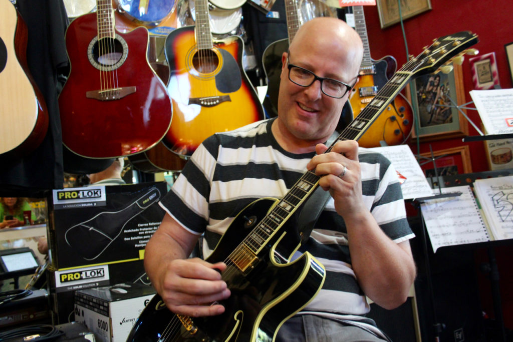Scott Simpson, 52, plays at Russell’s Music World in Norfolk during a what was, in part, an audition for the guitarist with local bandleader and drummer Russell Scarborough. Simpson recently moved to Virginia Beach to earn his doctorate at the divinity school at Regent University. [John-Henry Doucette/The Princess Anne Independent News] 
