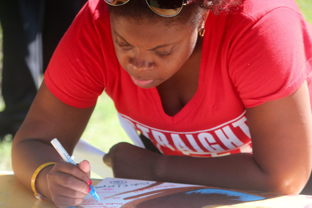 Tameka Neely of Chesapeake was among those to sign the tree on the painting. Those signatures are part of the work. Neely was among members of the Virginia Beach alumni chapter of Delta Sigma Theta who attended. [John-Henry Doucette/The Princess Anne Independent News]