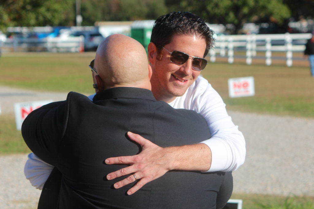Joash Schulman, secretary of Light Rail Now, Inc., accepted an invitation to attend a rally for No Light Rail Virginia Beach. He made brief remarks and hugged light rail opponent Jimmy Frost, who opposes extending The Tide. [John-Henry Doucette/The Princess Anne Independent News]